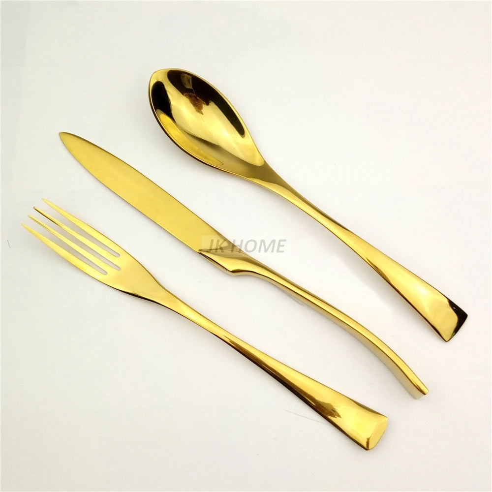 Set of gold cutlery including a fork and knife on a light gray background.