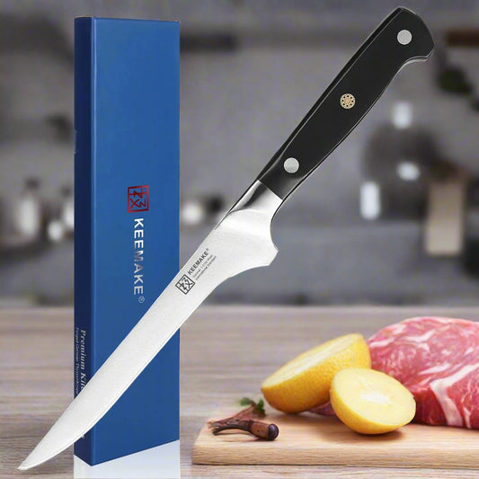 Knife with black handle and silver blade next to a blue KEEMAKE box on a white background