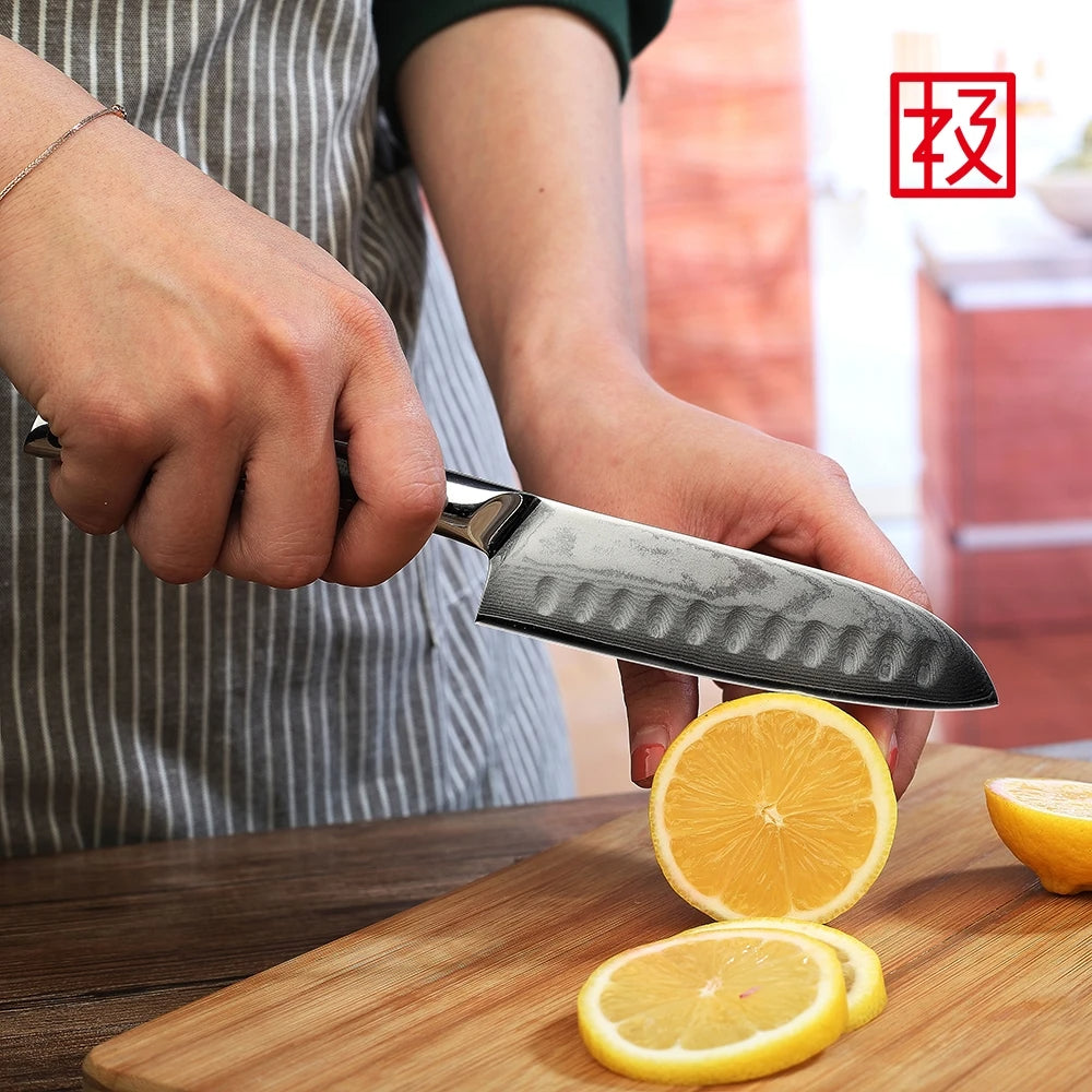 Person cutting a lemon with a knife on a wooden cutting board