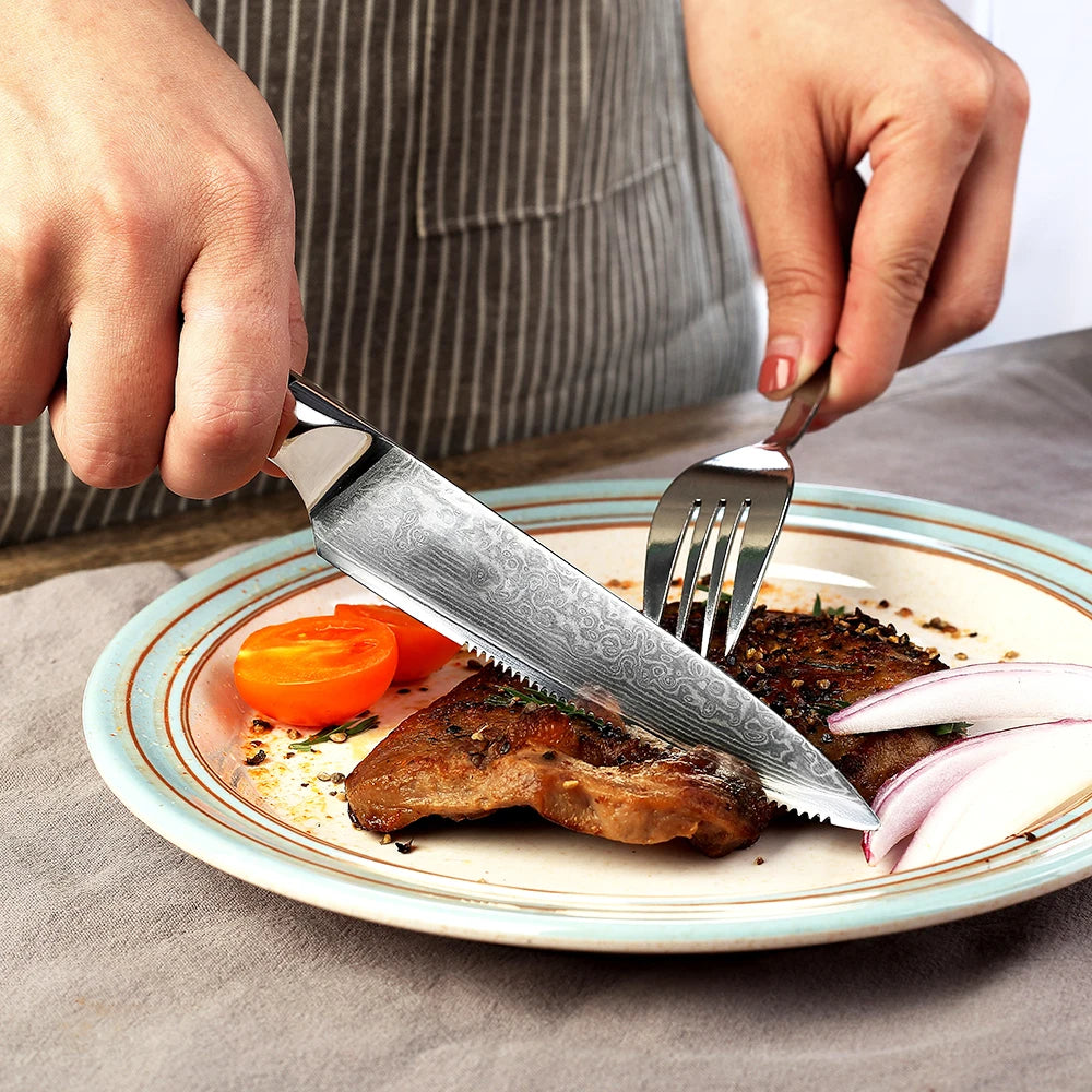Person cutting a steak with a knife and fork on a plate with vegetables.