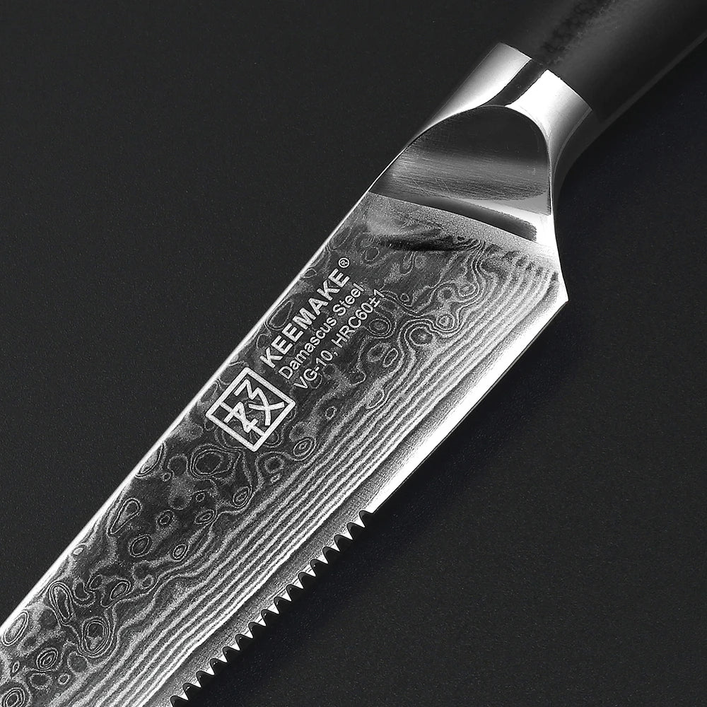 Close-up of a KEEMAKE knife blade with a dark background