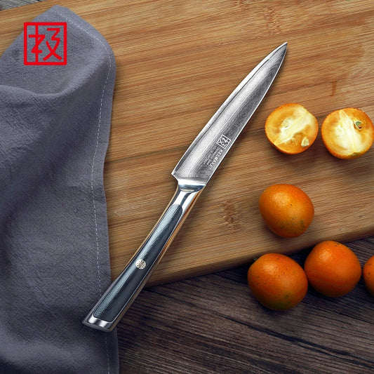 Knife on a wooden cutting board with oranges and a gray cloth