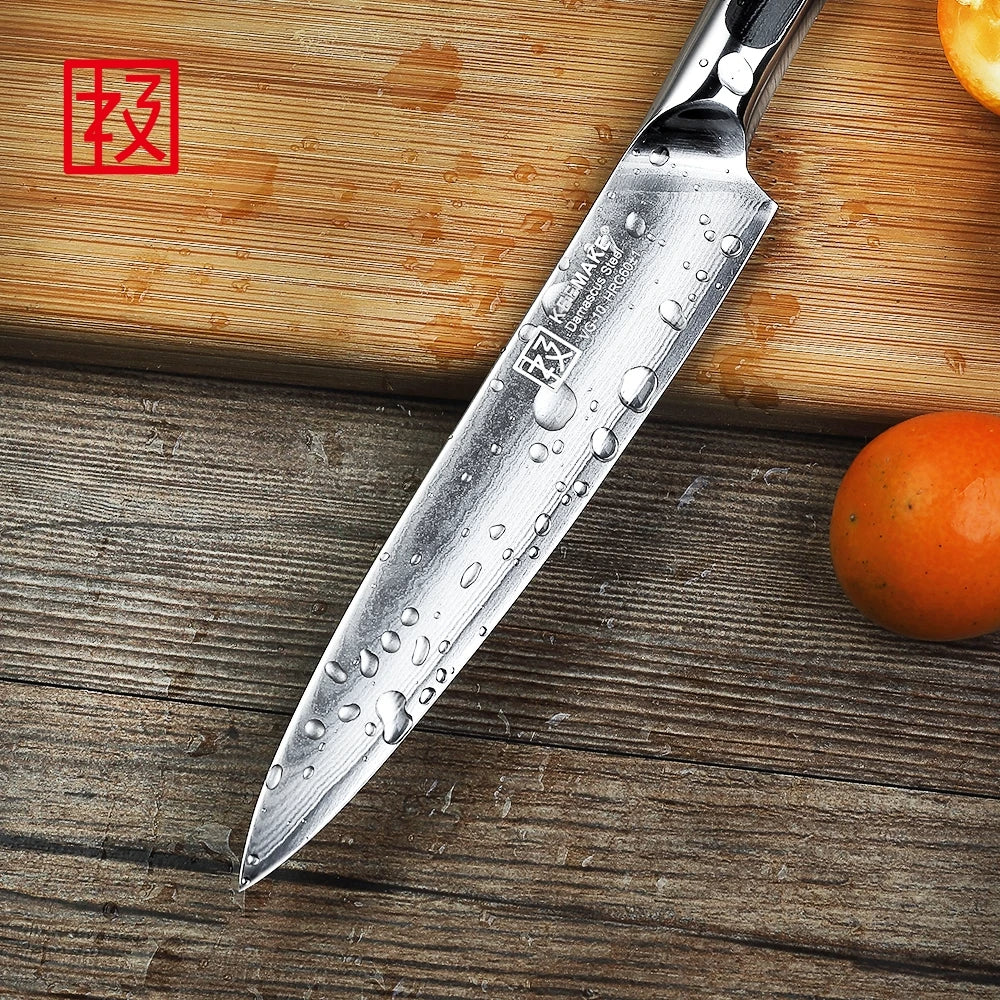 Chef's knife with water droplets on a wooden surface next to an orange