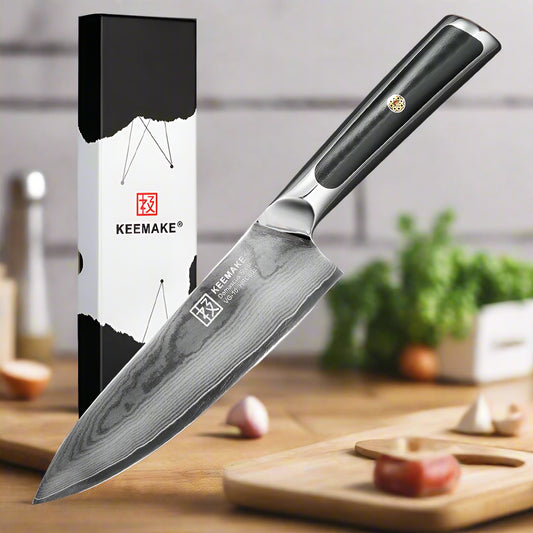 Chef's knife with black handle and KEEMAKE branding next to its packaging on a white background