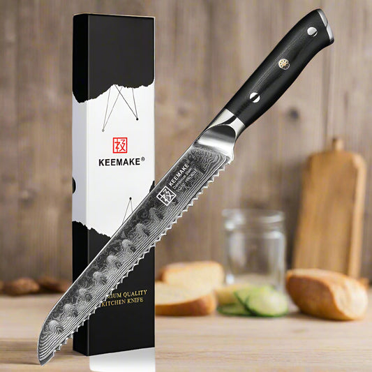 Kitchen knife with black handle and Damascus steel blade next to its packaging on a white background