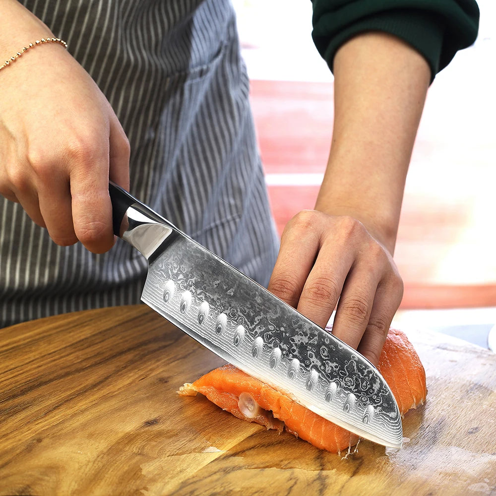 Person using a chef's knife to cut salmon on a wooden cutting board.