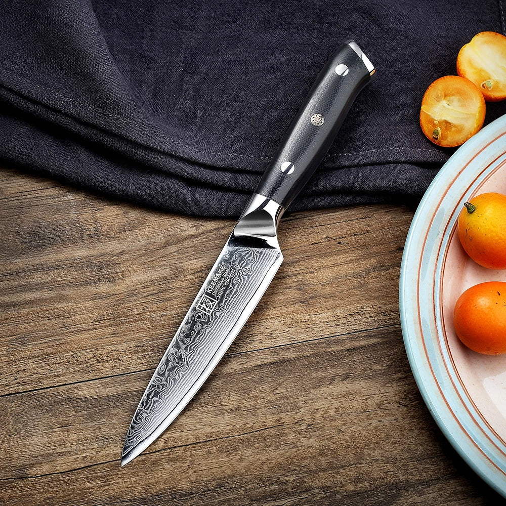 Decorative knife on a wooden surface with a plate of oranges.