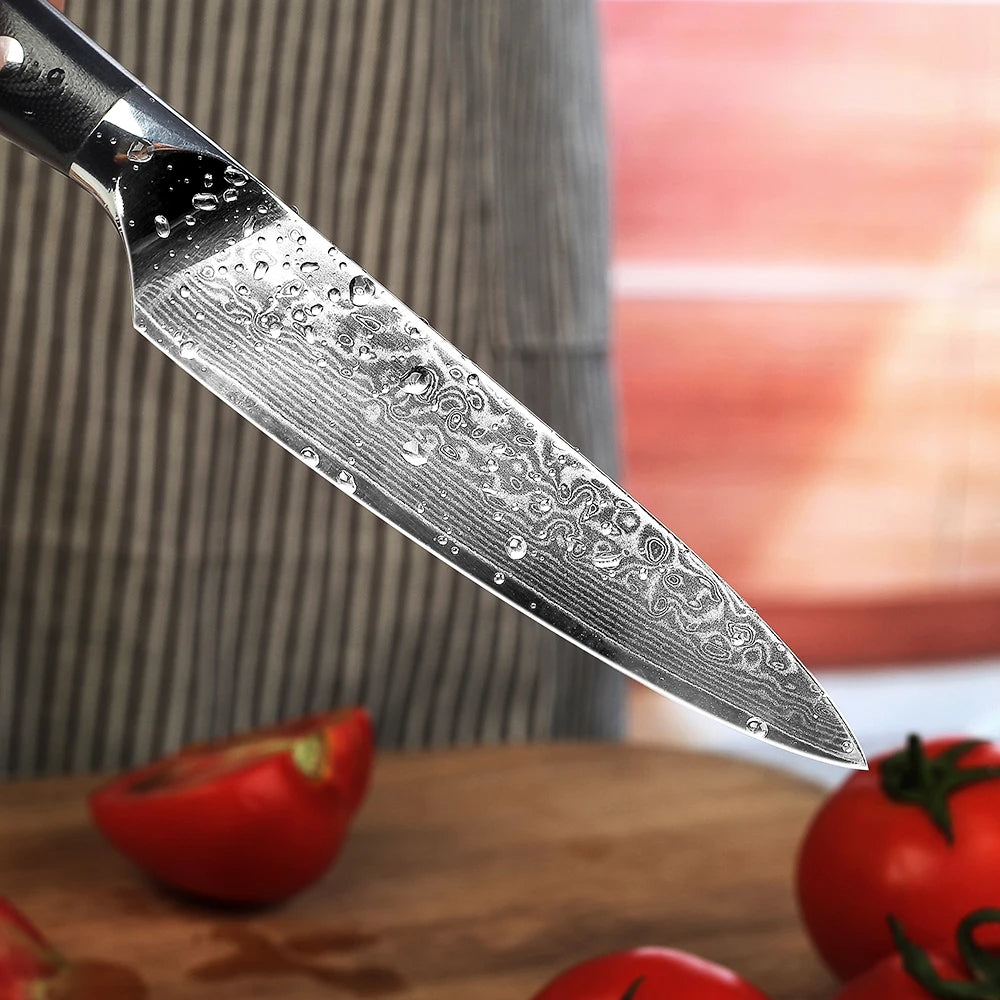 Decorative chef's knife with water droplets on a wooden surface with tomatoes