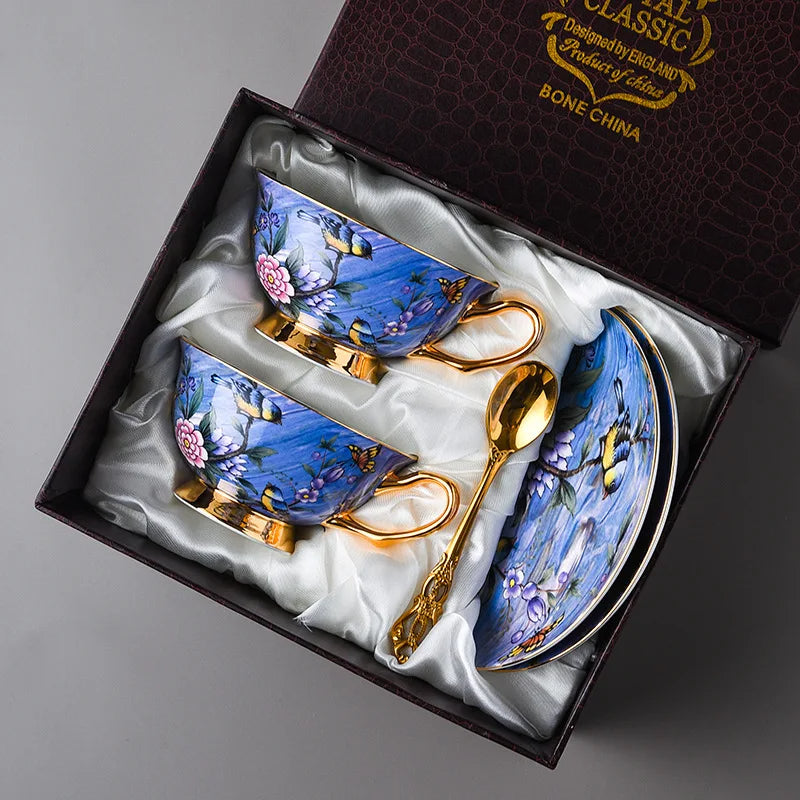 Set of blue teacups with gold handles and a spoon in a decorative box.