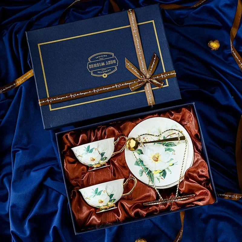 Tea set with two cups and a saucer in a decorative box on a blue fabric background