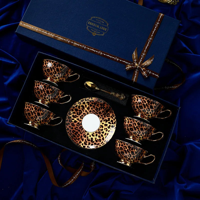 Set of leopard print tea cups and saucers in a decorative box on a blue fabric background