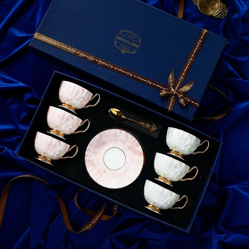 Set of ceramic tea cups and saucer in a decorative box on a blue fabric background
