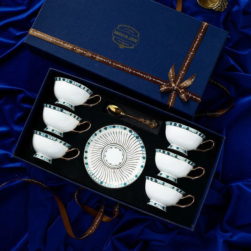 Tea set with four cups and a saucer in a decorative box on a blue fabric background