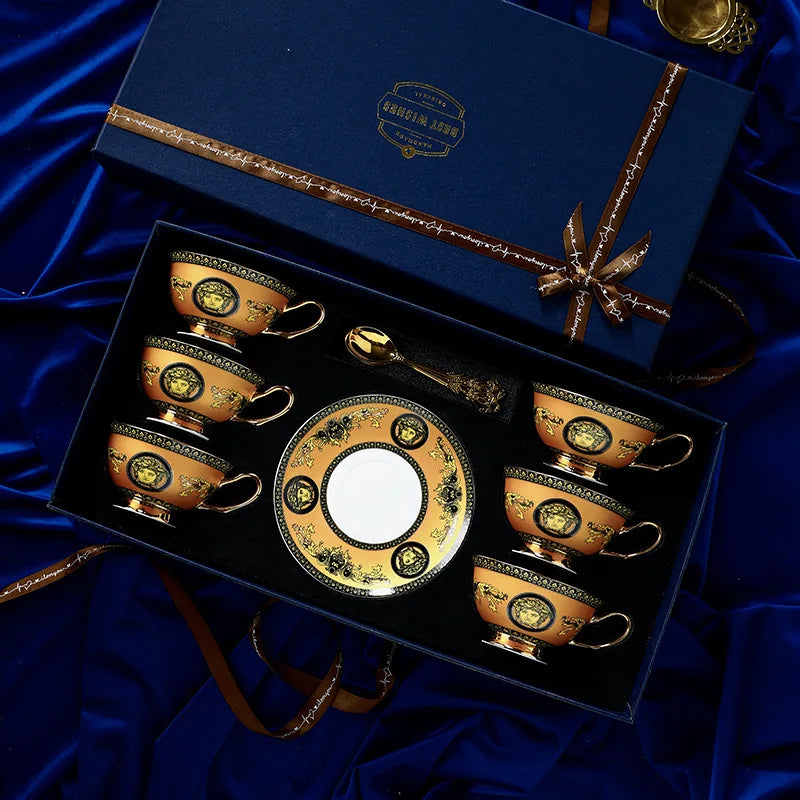Set of ornate teacups and saucer in a decorative box on blue fabric