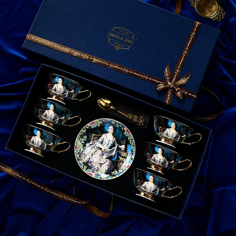 Set of decorative cups and saucers in a gift box on a blue fabric background