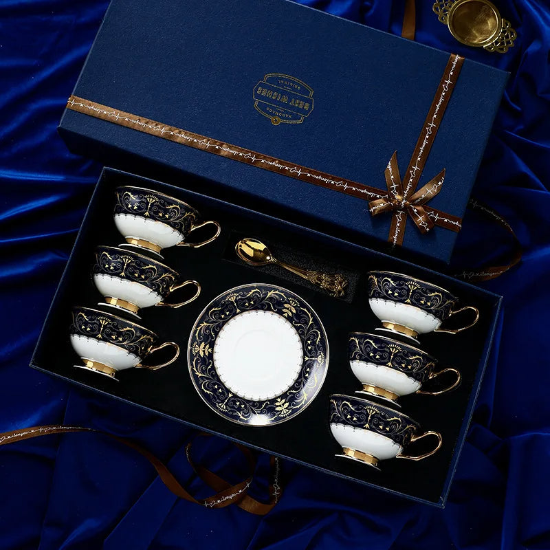 Set of ornate teacups and saucers in a decorative box on a blue satin background